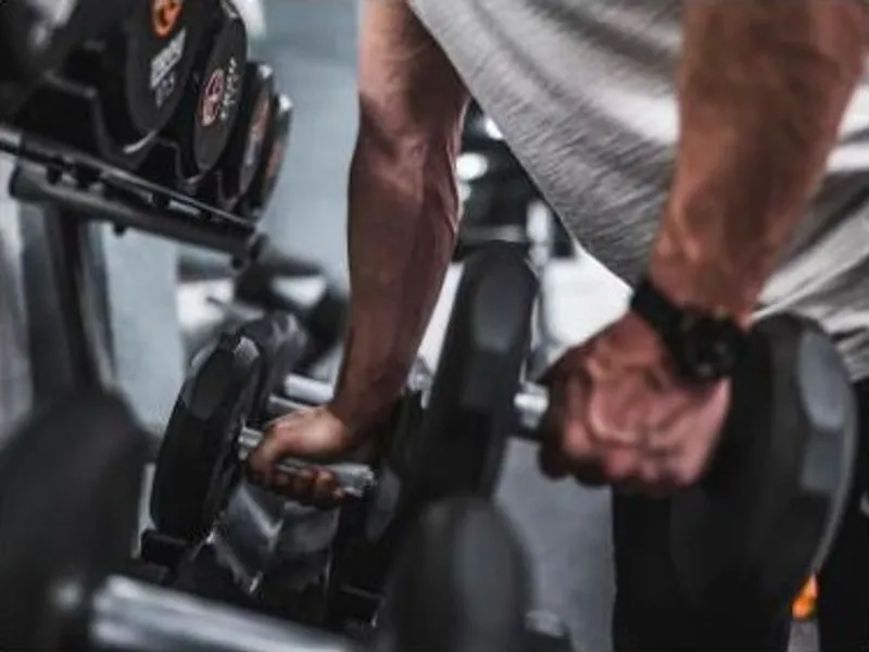 Arm holding a dumbbell during a strength exercise at the gym