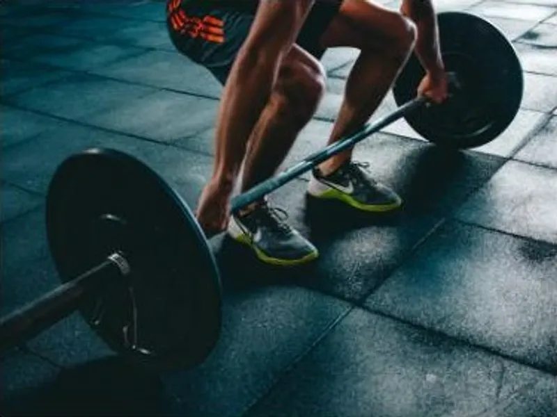 Person preparing to lift a loaded barbell in a deadlift