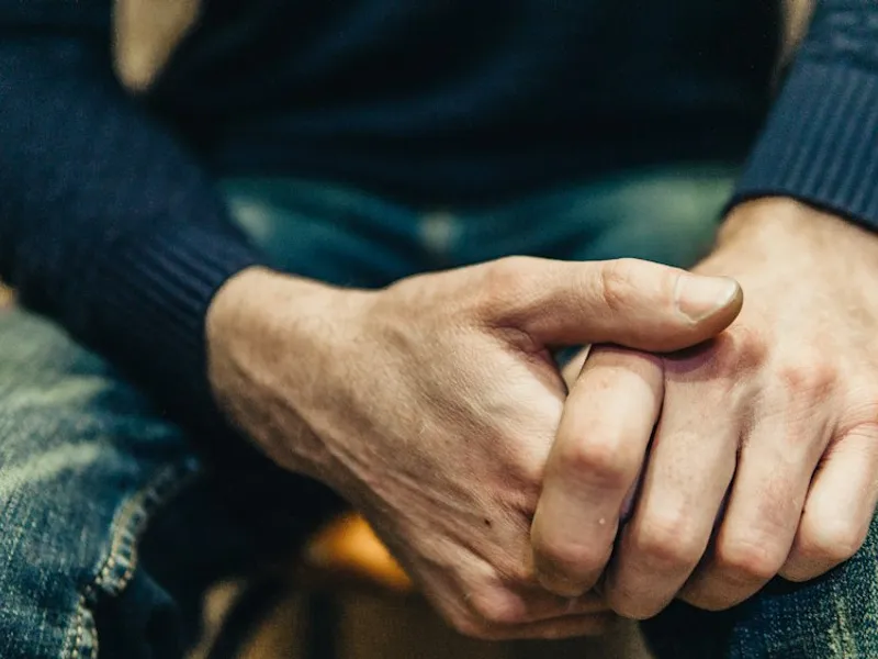 Dos manos entrelazadas sobre una mesa de madera